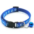 Close-up detail of blue pet collar with white paw print pattern and cute metal bell. - Blue