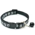 Gros plan détaillé du collier pour animal noir avec motif de pattes et cloche en métal. - Noir