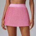 Close-up view of a pink pleated sports tennis skirt detail, showing quick-dry fabric texture. - S / Rose Pink