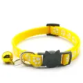 Yellow pet collar detail showing the cute cat buckle, paw print pattern and golden bell pendant. - Yellow