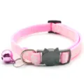 Detailopname van roze huisdierenhalsband met pootafdrukken, kattengesp en glimmende bel. - Roze