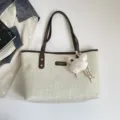 Canvas tote bag detail view, minimalist commuting shoulder bag with brown leather handles. - With Pendant / Brown