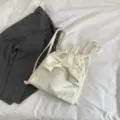 Primo piano dettagliato dello zaino bianco con motivo di stelle e un grazioso fiocco. - Bianco
