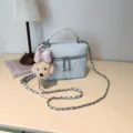 Chic light blue quilted vanity crossbody bag with chain strap and cute plush puppy charm. - Blue