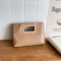 Vista dettagliata della pochette in pelle intrecciata cammello con manico intagliato in legno. - Kaki