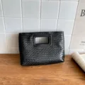 Borsa a pochette in pelle intrecciata nera con manico ritagliato, elegante dettagli. - Nero