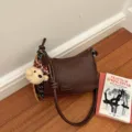 Stylish dark brown woven shoulder bag for women, featuring a cute plush bear pendant. - Coffee With Pendant