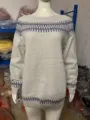 Detailed view of the casual crew neck knitted sweater with geometric blue patterns on cuffs and hem. - Gray Base With Blue Stripes