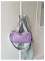 Vista detallada de un elegante bolso de hombro cilíndrico morado colgado en un gancho. - Púrpura