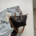 Detailansicht der schwarzen Segeltuchtasche mit Sternenmuster, modische Umhängetasche. - Schwarz
