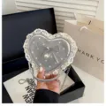 Gros plan du sac à main cœur argenté à pois blancs, bordure en dentelle crème et nœud de perle. - Argent