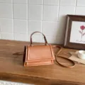 Elegante braune Damen Umhängetasche, schicke Handtasche mit Griff und Trapezklappe. - Braun