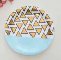 Nahaufnahme eines Einwegpapptellers mit metallischen goldenen geometrischen Dreiecken. - Goldfolien Dreieck / 9 Zoll 8er-Pack