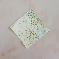 Close-up detail of disposable party paper napkin with green and gold polka dots pattern. - 16 Sheets Pack / Green