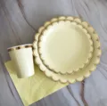 Ensemble de vaisselle jetable en papier avec assiettes et tasses festonnées dorées. - Service de 4 pièces : Grandes et petites assiettes, gobelets, serviettes / Assiettes rondes jaunes dorées à bords ondulés