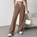 Detailed view of women's high-waisted brown wide leg sweatpants with adjustable drawstring. - S / Bottoms / Brown