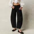 Detail view of casual loose black denim trousers featuring a stylish curved barrel leg design. - S / Black