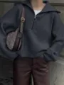 Detailopname van een donkergrijze geribbelde gebreide trui met halve rits en comfortabele pasvorm. - S / Tops / donkergrijs
