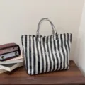 Black and white striped tote bag showing large capacity, vintage style and detailed texture design. - Black