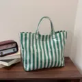 Green and white striped transparent tote bag detail shot showing high capacity fabric. - Green
