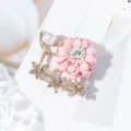 Gros plan d'une délicate broche fleur en tissu rose avec des perles et des strass étincelants. - Rose