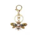 Detailed close-up of a gold-tone alloy bee keychain featuring enamel, pearl, and rhinestones. - Gold