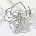 Nahaufnahme Detailaufnahme einer silbernen Spinnenbrosche mit einem funkelnden Kristall im Zentrum. - Silber
