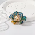 Detail shot of exquisite blue enamel peony brooch featuring sparkling rhinestones and center pearl accent. - Blue