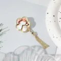 Primer plano de broche abanico con flor de ciruelo estilo chino y borla esmaltada. - Ciruela