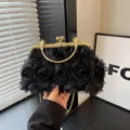 Dettaglio della borsa da sera con rose in rete nera e chiusura a bacio in metallo dorato. - Nero