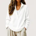 Close-up detail of the white waffle knit deep V-neck sweater fabric and sleeves. - White
