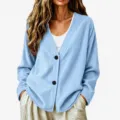 Primo piano del cardigan azzurro con collo a V in tessuto strutturato e bottoni scuri. - Celeste