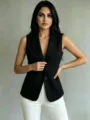 Close-up detail of the elegant black sleeveless blazer vest, featuring lapel and front button. - S / Tops / Black