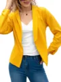Detailed view of the chic yellow lapel blazer paired with a white camisole and blue jeans. - Yellow