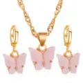 Detailopname van de roze acryl vlinderhanger en de bijbehorende gouden ketting set. - Set / Roze