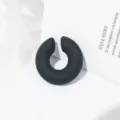 Dettaglio di orecchino a clip C nero opaco chuncky, orecchino minimalista senza foro. - Nero