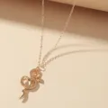 Close-up detail van de gouden slanghanger met gestructureerd lichaam en fijne ketting. - Goud