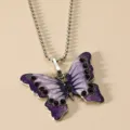 Gedetailleerde close-up van vintage paarse geëmailleerde vlinderhanger ketting met strass steentjes. - Kalketting en Paars
