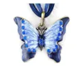 Detailopname van een vintage vlinderhanger van legering met blauwe emaille en strass-steentjes. - Antiek Brons en Blauw