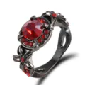 Gedetailleerd overzicht van een zwarte vintage ring met schitterend rode kristalbloem. - Maat 6 / Rood