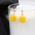 Charmante gele nepbont pompon oorbellen met gouden knoppen voor schattige herfst winterstijlen. - Geel