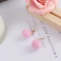 Leuke roze pluche pompon oorbellen detailopname, zachte bal met gouden stekker. - Roze