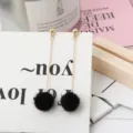 Lange gouden ketting oorbellen met pluizige zwarte pompons, elegante stijl voor vrouwen. - Zwart
