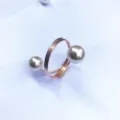 Primo piano di un elegante portatovagliolo a molla in oro rosa con perle per la tavola. - Oro rosa