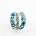 Detail van een meerlagige ring met blauwe en groene kristallen en strass-steentjes. - Maat 6 / Blauw