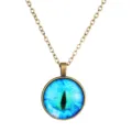 Detail shot of a vintage bronze chain necklace with a vibrant blue cat eye glass cabochon pendant. - Antique Bronze & Blue