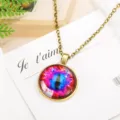 Detail shot of bronze chain necklace with colorful cat eye glass cabochon pendant design. - Antique Bronze & Red