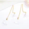 Detailed view of gold-plated long chain earrings featuring white fabric flower petals and pearls. - White