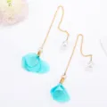Detailed close-up of elegant long tassel earrings featuring blue fabric flower petals and white pearls. - Blue