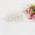Detail shot of disposable paper cups with elegant gold polka dots, styled with floral decor. - Bronzing Polka Dots